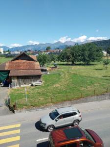 a silver car driving down a street next to a house at 1 Zimmer Unterkunft in Spiez