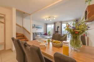 a dining room with a wooden table with a vase of flowers at Strandhaus Bernstein in Breege in Breege