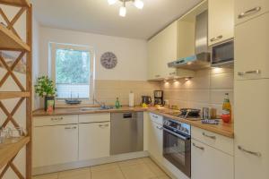 a large kitchen with white cabinets and a window at Strandhaus Bernstein in Breege in Breege +35 photos