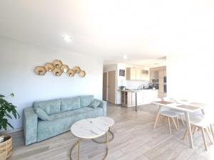 a living room with a blue couch and a table at Lana #Clim#Terrasse - Meublé classé 3étoiles in Clermont-Ferrand