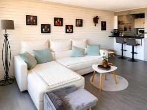 a living room with a white couch and a table at Schwarzwaldloge Zeitlos in Sasbachwalden