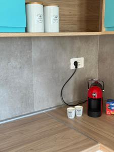 a red toaster sitting on a counter next to cups at Panorama View Holiday Home in Šušanj