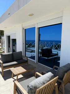 a patio with a couch and chairs and the ocean at Panorama View Holiday Home in Šušanj