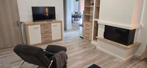 a living room with a television and two chairs at Paradise Vibe Balaton in Balatonkenese