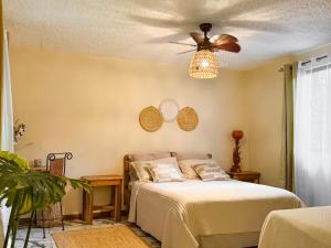a bedroom with a bed and a ceiling fan at Hotel Boutique Casa Mambo in Cahuita