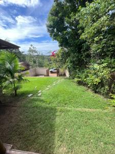 ein Hof mit grünem Gras und Bäumen und ein Haus in der Unterkunft Jeribucatu in Itacaré + 2 Fotos