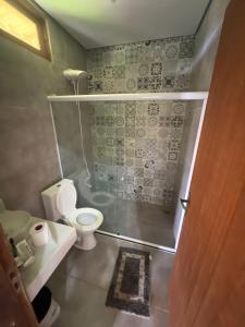 ein kleines Badezimmer mit Toilette und Dusche in der Unterkunft Jeribucatu in Itacaré