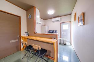 a kitchen with two chairs and a counter in a room at がじゅまる Miyako Hotel in Miyakojima +20 photos