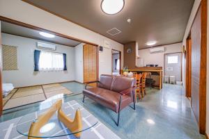 a living room with a chair and a table at がじゅまる Miyako Hotel in Miyakojima