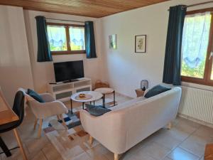 a living room with a couch and a tv at Duplex dans maison normande avec accès au jardin in Bernay