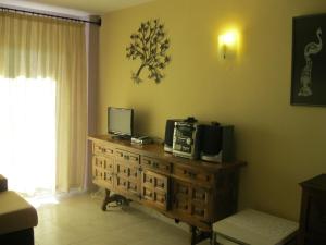 ネルハにあるEdificio Acapulcoのデスク、電子レンジ、テレビが備わる客室です。
