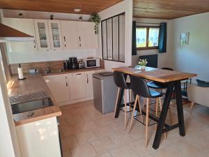 a kitchen with a table and chairs in a room at Duplex dans maison normande avec accès au jardin in Bernay