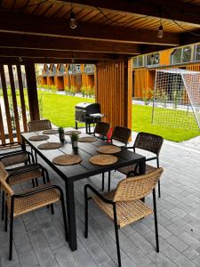 a table and chairs on a patio with a grill at Dominickie Antresole in Boszkowo-Letnisko +7 photos