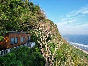 a house on a hill next to the ocean at Nunggalan Octopus 2 in Uluwatu