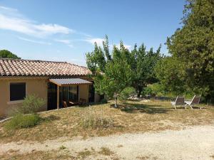 two chairs in a yard next to a house at maisonnette entre bois et champs in Crest +1 photo