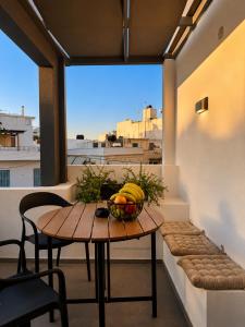 a table with a bowl of fruit on a balcony at Cabana Condo in Ierapetra