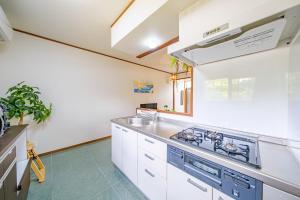 a kitchen with a sink and a stove at キジムナー MIYAKO Hotel in Miyakojima