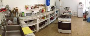 a kitchen with a sink and a stove at Hostal Surf Olón in Olón
