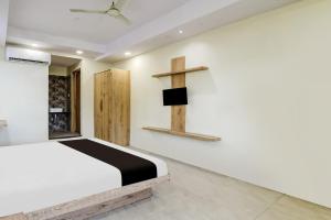 a room with a bed and a cross on the wall at Hotel O katyayani in Indore +18 photos