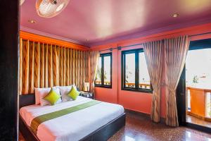 a bedroom with a bed with orange walls and windows at Golden Butterfly Villa in Siem Reap +81 photos