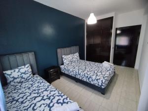 a bedroom with two beds and a blue wall at heartofrabat in Rabat