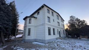 a white house with aventh floor at Guest house 97 in Karakol