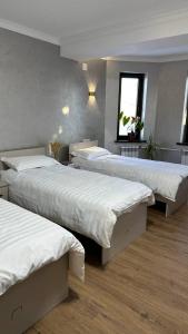 a room with three beds and a window at Guest house 97 in Karakol