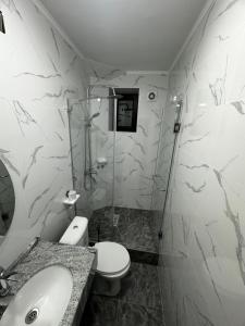 a bathroom with a shower and a toilet and a sink at Guest house 97 in Karakol
