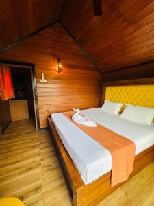 a bedroom with a bed in a wooden room at Villa I Did in Beruwala
