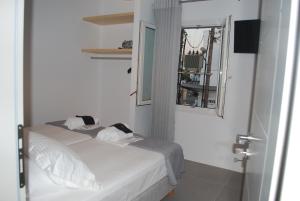 a small white bedroom with a bed and a mirror at Busho Residence 2 in Naousa