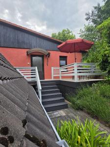 a red building with stairs and an umbrella at WoDa's Hütte in Wickerode