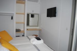 a white room with a bed and a television at Busho Residence 2 in Naousa