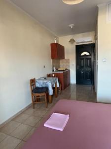a kitchen with a table and a purple rug at Karyatis studios lixouri in Lixouri
