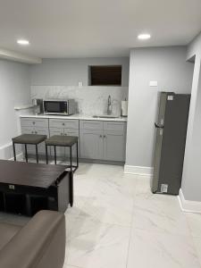 a kitchen with a refrigerator and some tables and chairs at Lg2NY in Westerleigh +10 photos