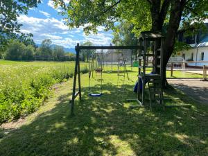 a swing set in the shade of a tree at Apartma Confine in Rateče +33 photos