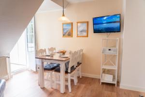 a dining room with a table and chairs and a tv at Lister Tor 01 in List