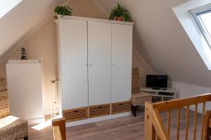 a large white cabinet in a room with a staircase at Lister Tor 01 in List