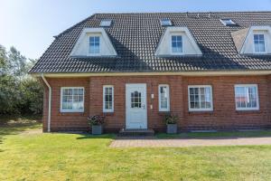 a red brick house with a white door and windows at Lister Tor 01 in List