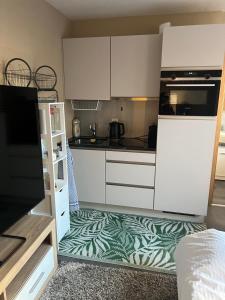 a kitchen with white cabinets and a green and white floor at Lake Studio in La Tour-de-Peilz
