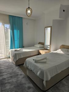 ein Schlafzimmer mit zwei Betten und einem großen Fenster in der Unterkunft Elfida Apart in Datca