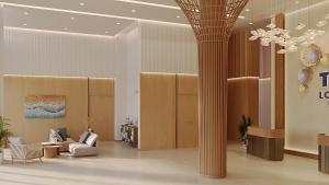 a lobby with a column and chairs and a chandelier at TTC Lotus Hotel in Phú Quốc