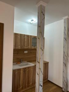 a kitchen with a sink and wooden cabinets at Вила Версай in Sarnitsa