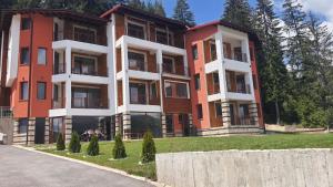 an apartment building with red and white at Вила Версай in Sarnitsa