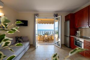 a living room with a couch and a kitchen with a table at Corfu Dream Holidays Villas in Glyfada