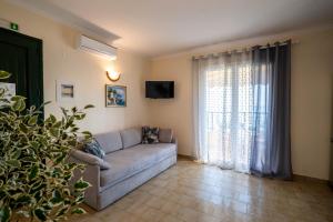 a living room with a couch and a large window at Corfu Dream Holidays Villas in Glyfada