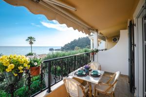 a balcony with a table and chairs and the ocean at Corfu Dream Holidays Villas in Glyfada