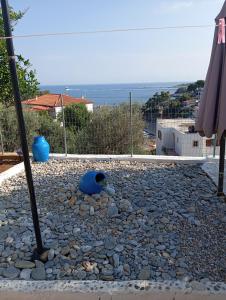 a patio with an umbrella and a stone walkway at George Rooms in Votsi
