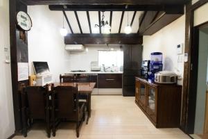 eine Küche und ein Esszimmer mit Tisch und Stühlen in der Unterkunft Kominka Wagaya in Higashiōsaka
