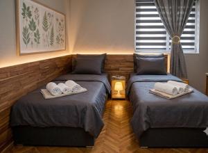 two beds in a room with towels on them at Apartment Wonderland in Niš +7 photos