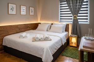 a bedroom with a bed with two towels on it at Apartment Wonderland in Niš